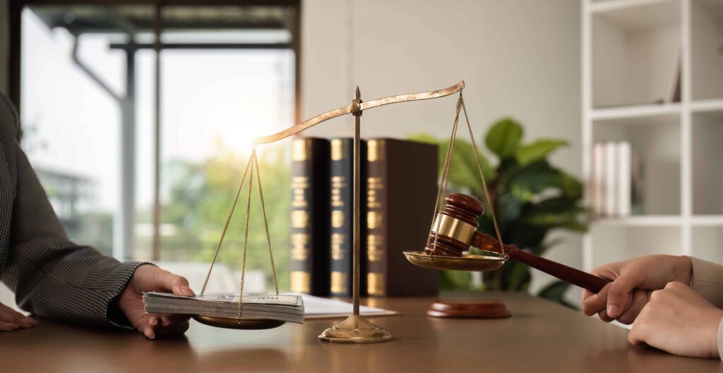 Scales of justice balancing money and a gavel in a law office, symbolizing legal settlements and financial justice.